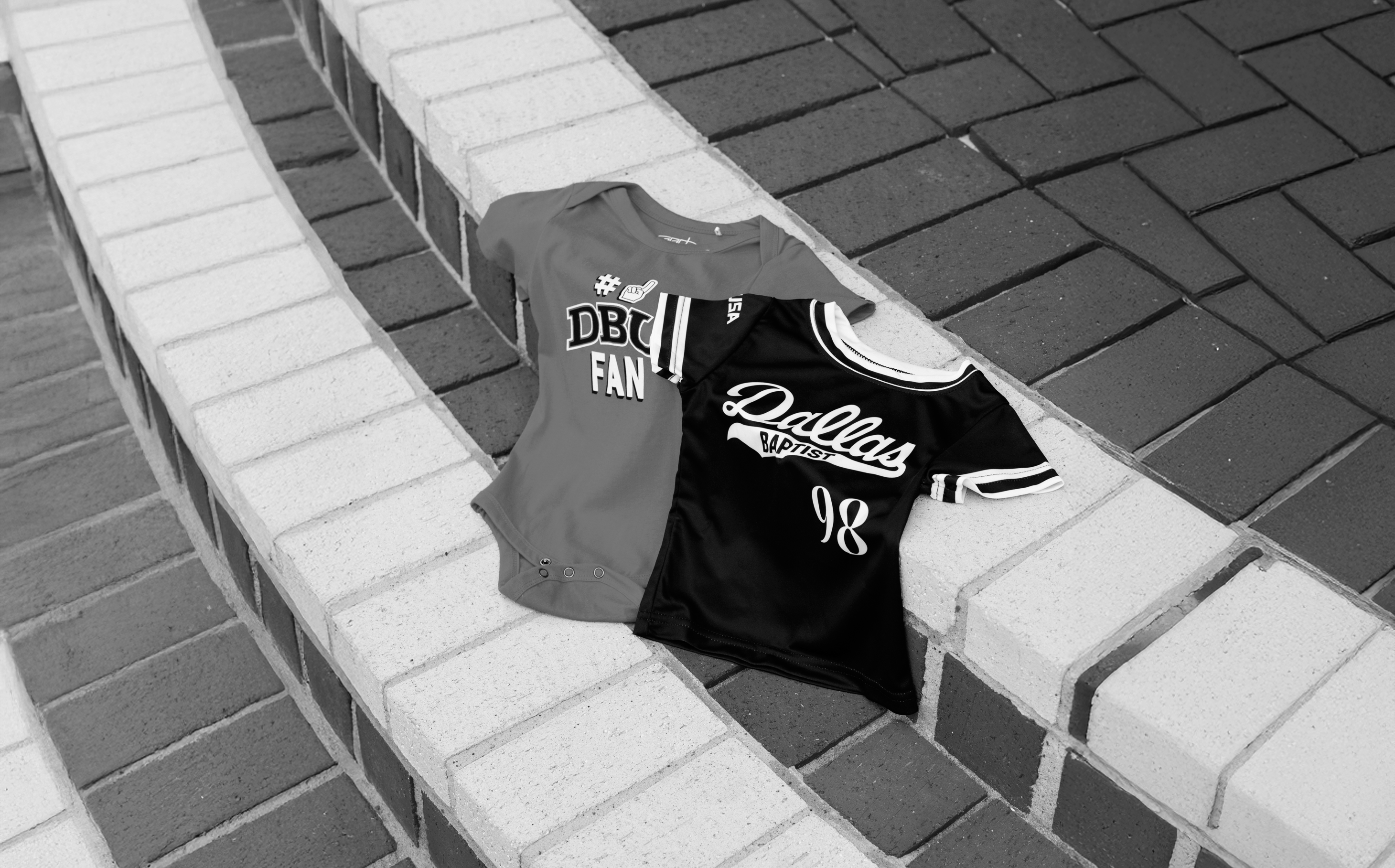 Two sports jerseys, one gray and one black with 'Dallas' text, on a tiled surface.