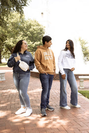 Three people standing on a brick path with trees in the background